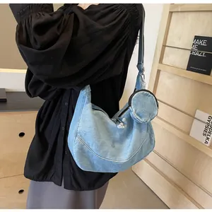 Dettaglio della borsa hobo in denim azzurro con mini portamonete rotondo abbinato