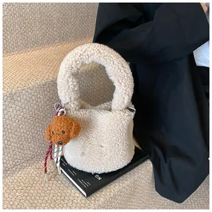 Detail der weichen cremefarbenen Lammfell-Tasche mit süßem braunem Pudel-Anhänger
