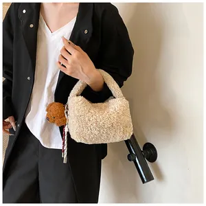 Detailansicht beige Plüschhandtasche mit süßem braunem Bären-Anhänger für den Winter