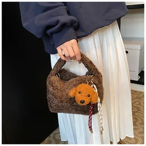 Detail der weichen braunen Plüschtasche mit süßem Hundeanhänger und Webseil-Dekoration