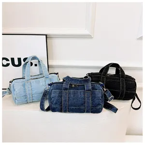 Three denim barrel bags in light blue, dark blue, and black with detachable straps