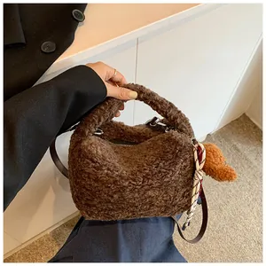 Nahaufnahme der flauschigen dunkelbraunen Teddy-Plüschtasche mit süßem Welpen-Anhänger