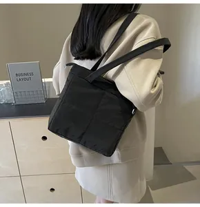 Detail of black quilted shoulder bag with soft padding and square stitching patterns