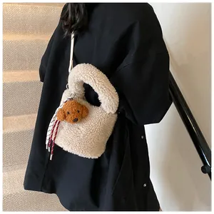 Detail der süßen beige Lammfell Beuteltasche mit Plüsch-Teddy auf dem Modell