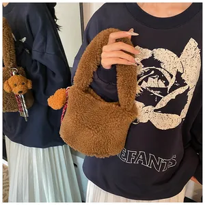Detail der braunen Plüschtasche aus Lammwolle mit einem süßen Hundeanhänger