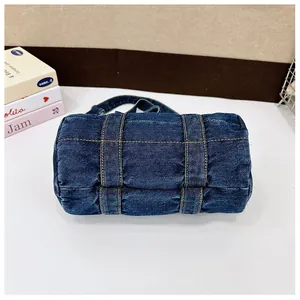 Detail of dark blue denim bucket bag with orange contrast stitching and retro texture