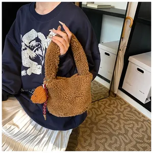 Nahaufnahme der braunen Plüschtasche mit süßem Bärenanhänger und Kordelverzierung