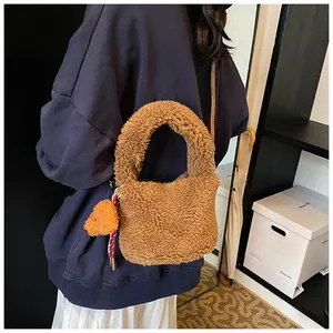Detailansicht der braunen Teddy-Eimertasche mit Bärenanhänger als Schultertasche