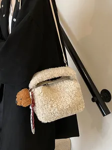Beigefarbene Plüsch-Beuteltasche mit Hundeanhänger auf schwarzem Wintermantel