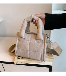 Quilted beige puffer bag with wide strap and padded texture for autumn winter