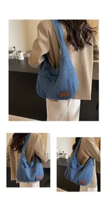 Detail of blue denim tote bag featuring leather brand logo patch and wide shoulder straps
