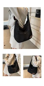 Detail of dark denim tote bag with brown leather logo patch and silver button pocket