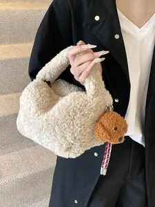 Beige Plüsch-Beuteltasche mit braunem Pudel-Anhänger auf strukturiertem Hintergrund