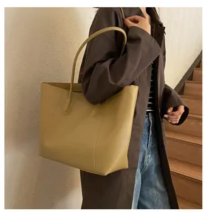 Macro detail of mustard yellow PU leather tote bag with reinforced shoulder straps