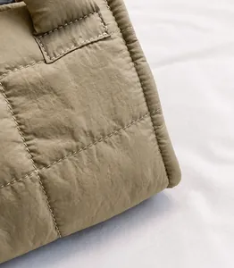 Close-up of quilted nylon fabric and reinforced stitching on olive green crossbody bag