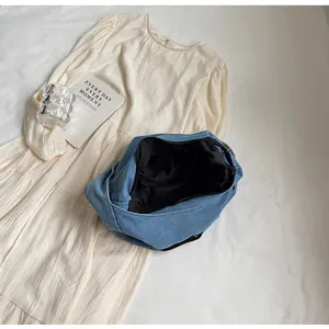 Detailed close-up of large blue denim hobo bag interior with zipper and black lining