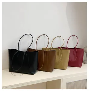Group display of large minimalist tote bags in black, brown, yellow, and burgundy colors