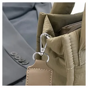 Macro detail of high-quality silver metal hook and leather strap on quilted crossbody bag