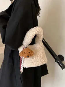 Schicke cremefarbene Fleece-Beuteltasche mit Pudel-Anhänger über schwarzem Mantel