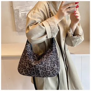 Detail der dunkelgrauen Hobo-Tasche mit Leopardenmuster, Lederriemen und Kettenelementen