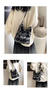 Close-up of vintage floral embroidery and black leather strap on a Chinese style tote