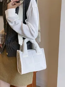 White quilted crossbody bag with adjustable wide strap and padded handle for casual look