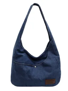 Deep blue denim hobo shoulder bag with front pocket and rivet on a white background