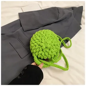 Detail der grünen handgefertigten Häkel-Umhängetasche mit Stricktextur und Riemen