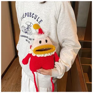 Dettaglio della trama a maglia della borsa a tracolla Babbo Natale rossa indossata su felpa