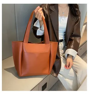 Detailansicht der karamellfarbenen Tragetasche mit großer Tasche und Ledertextur