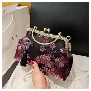 Détail du sac de soirée en satin brodé avec fermoir en strass et chaîne perlée