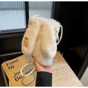 Détail d'un sac à bandoulière en peluche blanche avec cordon et breloque carotte