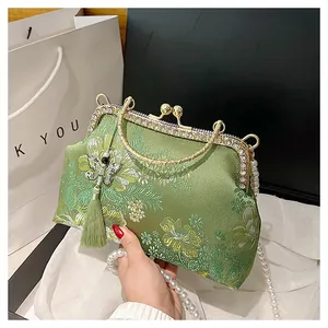 Broderie détaillée de fleurs sur sac en soie verte avec chaîne en perles et pompon