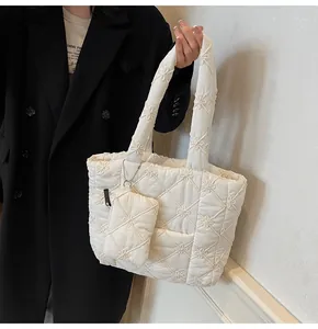 Detail of white quilted tote bag with floral embroidery and small matching coin purse