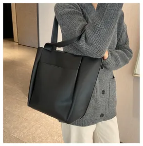 Detailansicht der schwarzen minimalistischen Tragetasche mit Lychee-Struktur und Fronttasche