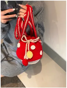 Close-up of handmade crochet mushroom bucket bag with red polka dots and drawstring