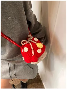 Detailed close-up of a handmade crochet mushroom crossbody bag with white polka dots