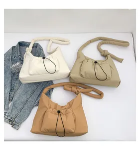 Tre borse trapuntate color panna, beige e caramello con tasche esterne con coulisse