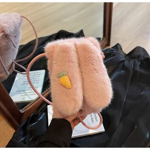 Détail d'une pochette rose en peluche avec un appliqué de carotte brodé mignon