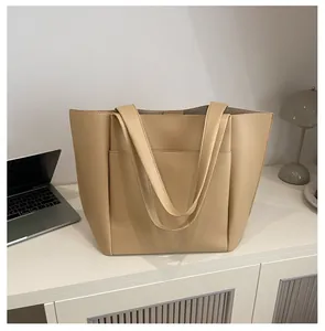 Detailaufnahme der beigen Tragetasche aus Kunstleder mit Lychee-Struktur und Fronttasche