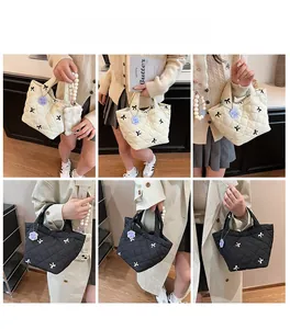 Quilted bow handbag with beaded strap detail shown in black and cream beige colors