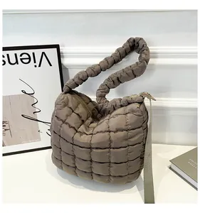 Macro detail of dark khaki quilted cloud bag with puffy texture and zip closure