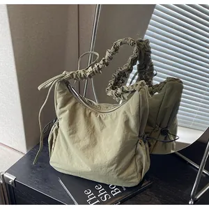 Detail of olive green nylon cloud bag with ruched drawstring shoulder strap and zipper