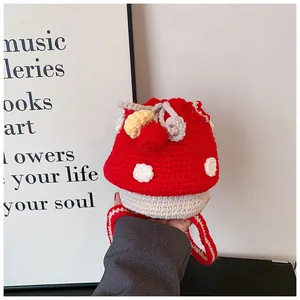 Detail of red and white mushroom crochet bucket bag showing hand-knitted texture and drawstring