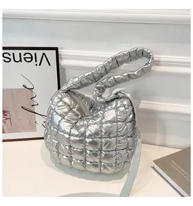 Detailed view of silver quilted cloud bag with puffy padded handles and zipper closure