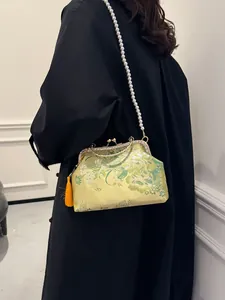 Sac à main chinois brodé de fleurs avec chaîne en perles et pompon sur modèle