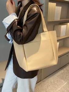 Große cremefarbene Shopper-Tasche aus Kunstleder mit Kieseltextur, am Modell präsentiert