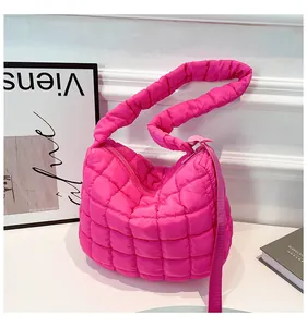 Macro view of hot pink quilted shoulder bag with puffy square stitching and zipper detail