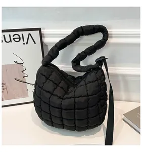 Close-up of black quilted puffer bag featuring adjustable strap and matte nylon texture