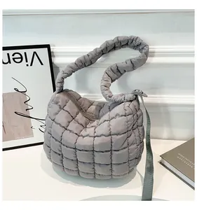 Detail of grey puffer cloud bag showing quilted nylon texture and zipper closure